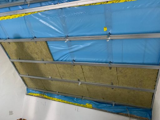 Decke mit blauer Folie und Montageprofil, isolierende Materialien sichtbar.